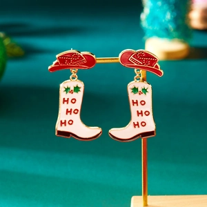 Detail van kerst cowboylaars oorbellen met HO HO HO tekst op donkergroen fluweel