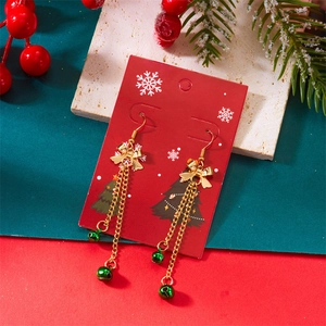 Detailed view of Christmas tassel earrings with gold bows and green festive bells
