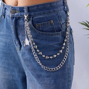Chaîne de taille argentée à trois couches avec pendentifs cœur et étoile sur jean
