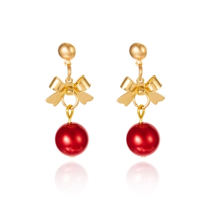 Detail of Christmas bow earrings with gold studs and glossy red beads on white background