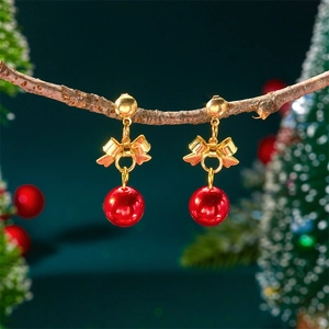 Christmas red gold ball earrings with bow and fringe details on a rustic branch