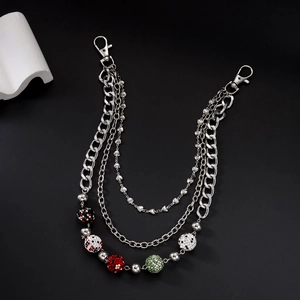 Détail de chaîne argentée triple épaisseur avec boules strass et pendentif cœur