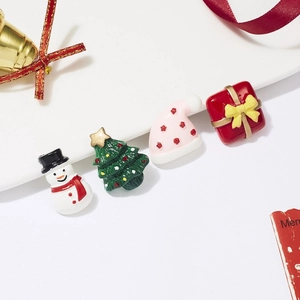 Macro detail of acrylic Christmas charms featuring snowman, tree, hat and gift box