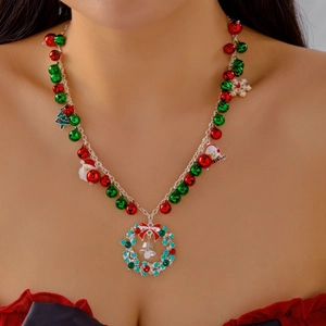 Détail d'un collier de Noël festif avec des breloques en émail Père Noël et bonhomme de neige