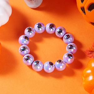 Dettaglio di perline viola iridescenti con stampe di ragni su bracciale Halloween