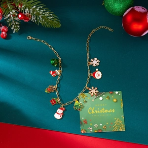 Detail van de gouden ketting met kleurrijke emaille kersthangers op een rode achtergrond