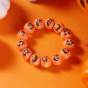 Dettaglio di perline di zucca arancione iridescenti con stampe Jack-o'-lantern spaventose