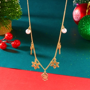 Détail d'un collier de Noël doré avec Père Noël, canne à sucre et perles sur fond rouge