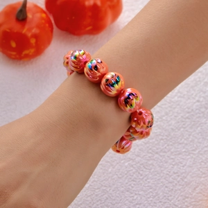 Dettaglio del bracciale di perle di zucca di Halloween con motivi Jack-o'-lantern