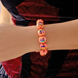 Bracciale di Halloween con perle a zucca arancioni iridescenti indossato sul polso