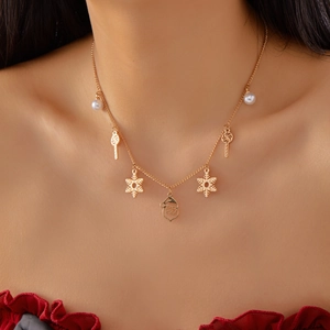Détail du collier de Noël doré avec pendentifs Père Noël et perles sur le cou