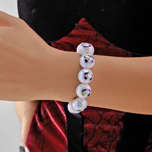 Dettaglio delle perline di Halloween iridescenti con fantasmi su un bracciale elastico