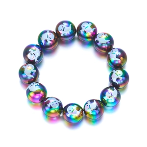 Dettaglio del bracciale di perle iridate di Halloween con stampe di fantasmi bianchi