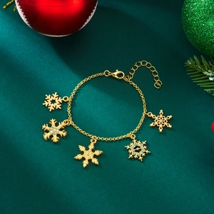 Golden Christmas snowflake charm bracelet with sparkling rhinestones on festive green background