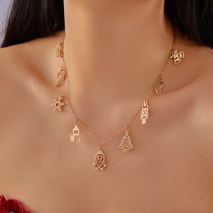 Gros plan d'un collier de Noël doré avec des breloques bonhomme de neige et Père Noël
