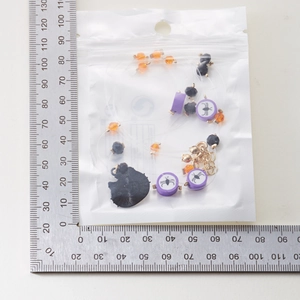 Detail view of Halloween beaded necklace with spider charms in retail packaging