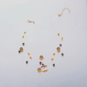 Detail of Halloween ghost pendant and layered beads on a transparent necklace