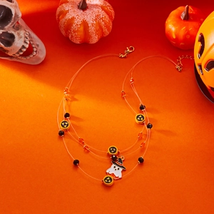 Multilayer Halloween necklace with ghost pendant and beads on festive orange background