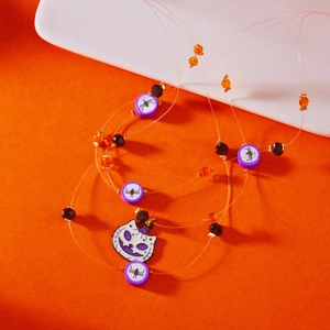 Macro detail of Halloween cat pendant with purple spider beads and crystal necklace