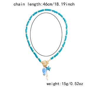 Detail of beaded ocean necklace with ceramic fish, starfish charm and gold OT buckle