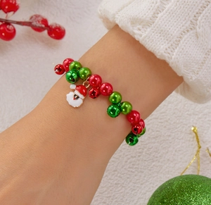 Dettaglio del bracciale natalizio con perline rosse verdi e ciondolo di Babbo Natale