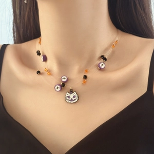 Detail of Halloween cat pendant layered necklace with purple beads and spider motifs