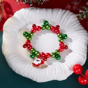 Dettaglio del braccialetto natalizio con perline e ciondolo Babbo Natale in stile festivo