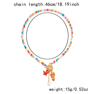 Detail of colorful beaded necklace with ceramic fish, starfish charm and gold OT buckle