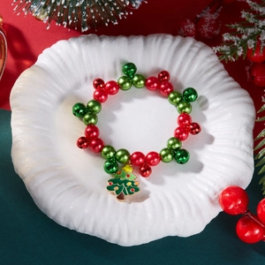 Dettaglio del bracciale natalizio con perline, campanelli rossi e verdi e ciondolo