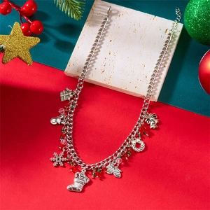 Detail van de kerstketting met feestelijke bedeltjes en rood-groene kralen op stenen bord
