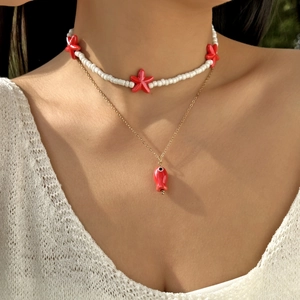 Close-up of double layer necklace with red fish pendant and sea star beads