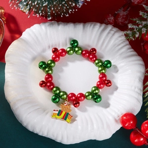 Dettaglio del bracciale di Natale con perline rosse e verdi e ciondolo a forma di orso