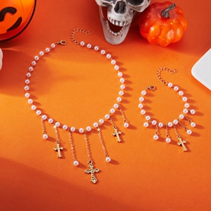 Détail de parure bijoux perles gothique avec pendentifs croix sur fond orange
