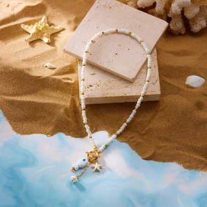 Close-up of ocean-style beaded necklace with ceramic fish, starfish and pearl charms