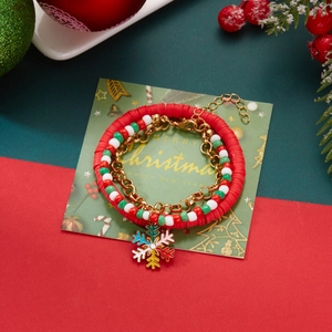 Macro detail of Christmas bracelet set with red clay beads and enamel snowflake charms