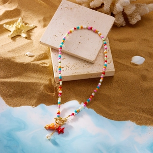 Detail of colorful beaded necklace with orange fish, starfish charms and toggle clasp