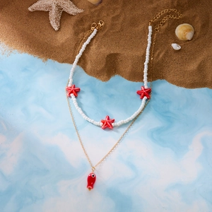 Detail view of ocean-themed double layer necklace with starfish beads and red fish pendant