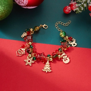 Close-up of Christmas charm bracelet with gold reindeer and Santa pendants on festive beads