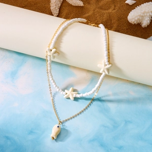 Detail of double-layer ocean necklace with starfish beads and a ceramic fish pendant