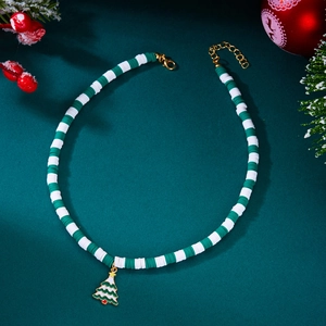 Close-up of green and white beaded Christmas tree necklace with festive berry background