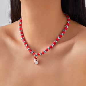 Detail of festive double-layer beaded necklace with snowman enamel charm and heishi beads
