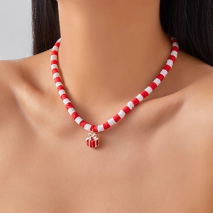 Close-up of a festive Christmas necklace with red and white Heishi beads and gift box charm