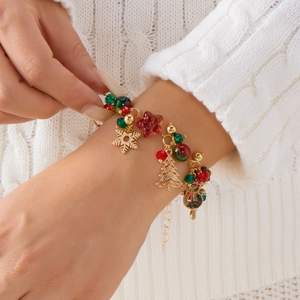 Christmas charm bracelet with Santa, tree, and snowflake pendants on a gold chain