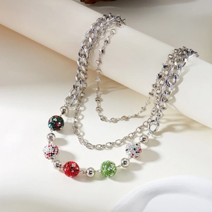 Détail du collier à trois rangs avec chaîne cubaine, maillons cœur et perles strass
