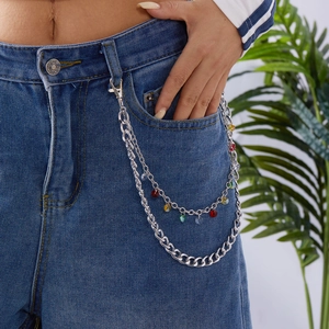 Détail d'une chaîne de pantalon argentée multicouche avec gemmes colorées