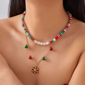 Detail of layered Christmas necklace featuring MERRY beads, red-green bells and snowflake