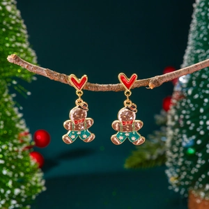 Boucles d'oreilles bonhomme en pain d'épice de Noël avec cœurs rouges sur une branche