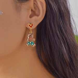 Gros plan d'une boucle d'oreille bonhomme de pain d'épice portée par un modèle