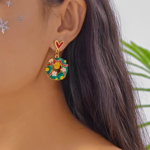 Vue détaillée d'un modèle portant une boucle d'oreille couronne de Noël et cœur