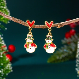 Gros plan détaillé de boucles d'oreilles bonhomme de neige avec clous en cœur rouge